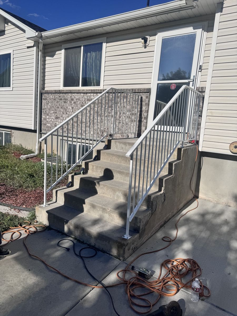 New light-colored steel railing on the same concrete entry steps