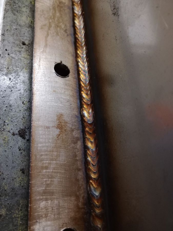 Close-up of a stacked-dime weld bead with gold and blue heat tint