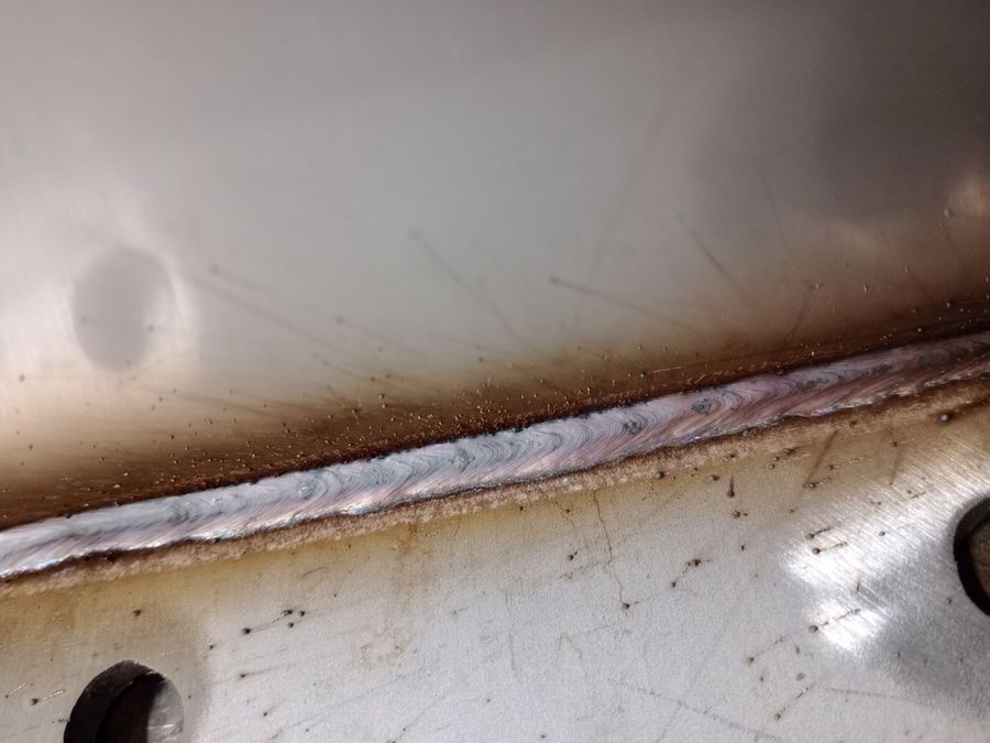 Close-up of a smooth silver weld bead along a steel seam